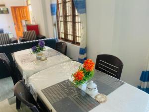 uma mesa com flores em cima com cadeiras em Hotel Randiya em Nallathanniya