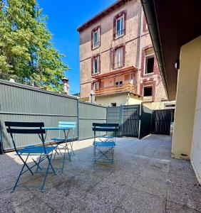 duas cadeiras e uma mesa em frente a uma cerca em 03 T2 Immeuble Le GD em Jarny