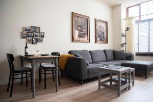 un soggiorno con divano e tavolo di Appartement aan de Geul a Valkenburg