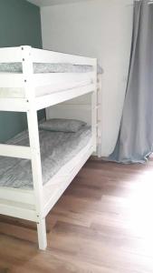kilka białych łóżek piętrowych w pokoju w obiekcie chambres d'hôtes rue Pasteur w mieście Is-sur-Tille