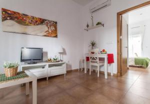 sala de estar blanca con TV y mesa en San Juan Apartamento, en Jerez de la Frontera