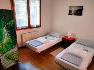 Cette chambre comprend deux lits et un canapé. dans l'établissement Appartamento AZZURRO, à Cannobio