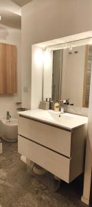 a bathroom with a sink and a mirror and a toilet at Hostdomus - Stoccolma Suite in Sestriere
