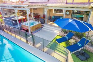 einen Blick über ein Haus mit Pool und Sonnenschirm in der Unterkunft Home w 5BR, Pool, Hot Tub, Gameroom, near Strip in Las Vegas