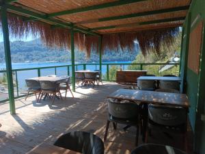 d'une terrasse avec tables et chaises et vue sur l'eau. dans l'établissement Paşa Bungalov HOTEL, à Marmaris