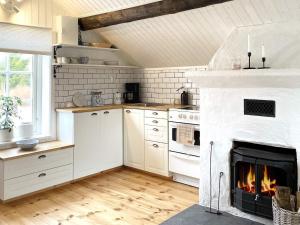 ArkösundにあるHoliday home VIKBOLANDET IIIの白いキッチン(暖炉付)