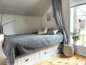 um quarto com uma cama num quarto com uma janela em Holiday home VIKBOLANDET III em Arkösund