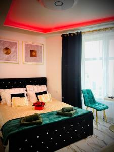 a bedroom with a large bed with a green blanket at Apartament z jacuzzi - Centrum Szczytna Mazury in Szczytno