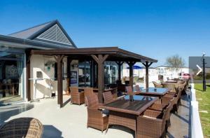 - un pavillon avec une table et des chaises sur la terrasse dans l'établissement 23 The Lawns Pevensey Bay Holiday Park, à Pevensey
