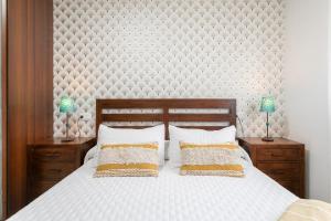 een slaapkamer met een groot wit bed met 2 lampen bij Legado Marino in Santa Pola