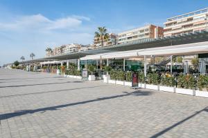 a street with white umbrellas and potted plants at Legado Marino in Santa Pola