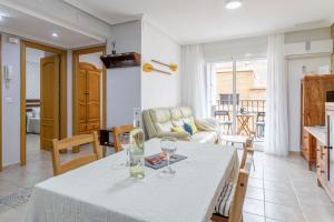 een keuken en een woonkamer met een tafel met wijnglazen bij Legado Marino in Santa Pola