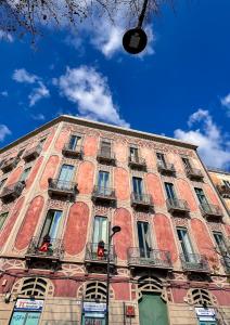 un edificio alto de ladrillo rojo con ventanas y un cielo azul en Promenade B&B en Catania