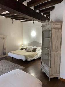 a bedroom with two beds and a large wooden cabinet at Gite de Foulleray n 14 in Rouez