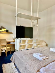 een slaapkamer met een bed en een flatscreen-tv bij Ferienhaus Weserblick am Sandstrand mit Dart, Billard und Tischkicker in Berne