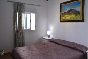 a bedroom with a bed and a picture on the wall at Casa Rural Arguayoda in Alajeró