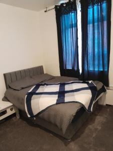 sypialnia z łóżkiem z niebieskimi zasłonami w obiekcie Brewerton w mieście Lees