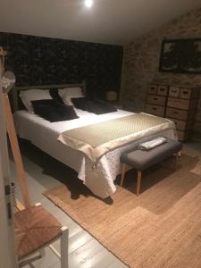 um quarto com uma cama grande e uma cadeira em Maison de vacances avec charme em Xaintrailles