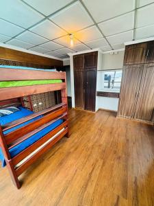 a room with bunk beds and a wooden floor at Departamento Torre Azul in Cuenca