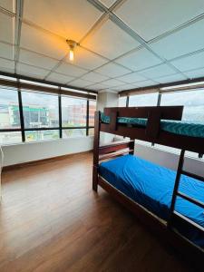 a bedroom with two bunk beds in a room with windows at Departamento Torre Azul in Cuenca