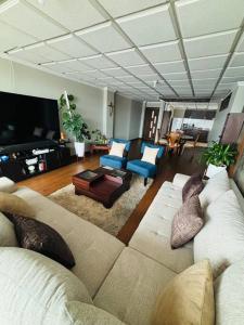 a large living room with a couch and chairs at Departamento Torre Azul in Cuenca
