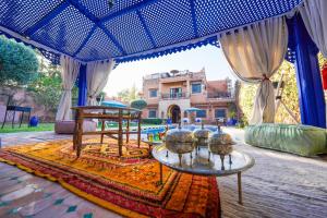 a view of a house from under a tent with a table at Villa Timskrine - Panoramic Mountains View in Marrakesh