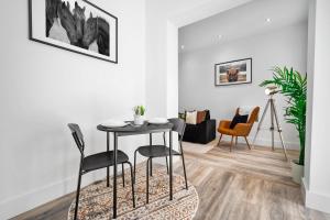 - un salon blanc avec une table et des chaises dans l'établissement Stylish Apartment with Free Wifi & Netflix 49aG, à Rowley Regis