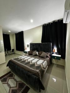 ナグアにあるHotel Mi Dulce Amanecer PyRのベッドルーム1室(黒いカーテン付きの大型ベッド1台付)