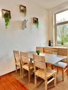 comedor con mesa y sillas en Ferienhaus Weserblick am Sandstrand mit Dart, Billard und Tischkicker, en Berne