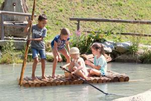 un grupo de niños en una balsa en el agua en Enzianhof - Nature Apartments, en San Giovanni in Val Aurina