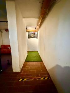 a small hallway with a green floor and a white wall at Ferienhaus Weserblick am Sandstrand mit Dart, Billard und Tischkicker in Berne