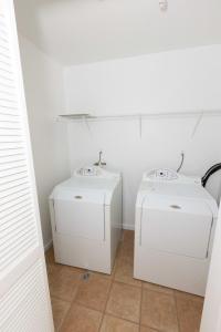 two washers and dryers in a white room at Stylish & Spacious 3-bed Apt mins to NYC in Jersey City