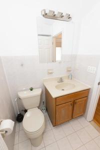 a white bathroom with a toilet and a sink at Stylish & Spacious 3-bed Apt mins to NYC in Jersey City