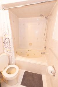 a bathroom with a toilet and a bath tub at Stylish & Spacious 3-bed Apt mins to NYC in Jersey City