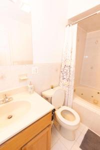 a bathroom with a toilet and a sink and a shower at Stylish & Spacious 3-bed Apt mins to NYC in Jersey City