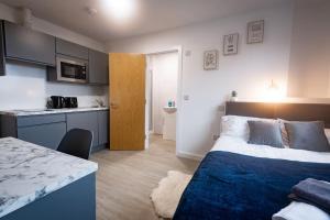 małą sypialnię z łóżkiem i kuchnią w obiekcie Old Trafford : Stunning Studio w Manchesterze