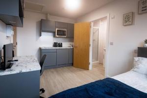 a small room with a bed and a kitchen at Old Trafford : Stunning Studio in Manchester
