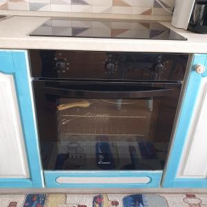 un forno nero in un mobile blu in cucina di Appartamento Guardastelle Holiday House a Rapallo