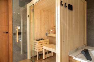 a sauna with a shower and a sink at CASES CERDANYA MOUNTAIN RESIDENCES in Bellver de Cerdanya