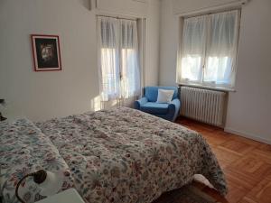 a bedroom with a bed and a blue chair at Casa Tina in Verbania