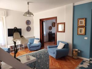 uma sala de estar com duas cadeiras azuis e uma mesa em Casa Tina em Verbania