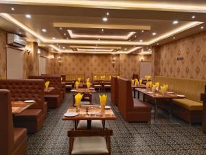 a restaurant with wooden tables and brown chairs at Hotel Windsor Plaza in Hyderabad