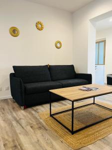 Sala de estar con sofá negro y mesa de centro en Opal'House, en Boulogne-sur-Mer