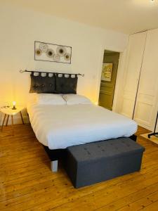 1 dormitorio con cama blanca grande y banco en Opal'House, en Boulogne-sur-Mer
