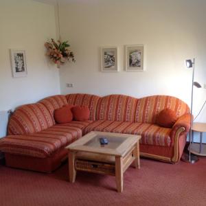 a living room with a couch and a coffee table at Pension beim Krümmling in Reutte