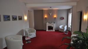 a living room with white chairs and a fireplace at Pension beim Krümmling in Reutte