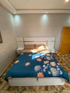 a bedroom with a bed with a blue comforter at دار الياقوت Dar Al Yaqut in Dakhla