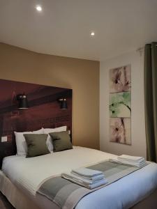 Un dormitorio con una cama grande con toallas. en La GARE de Lamalou, en Lamalou-les-Bains