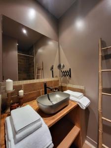 Un baño con lavabo y un espejo grande. en La GARE de Lamalou, en Lamalou-les-Bains