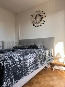 - une chambre avec un lit et une horloge murale dans l'établissement Jeux Olympique au Cœur de Paris, à Saint-Cloud